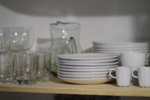 a shelf with cups and plates and glasses on it at Apartament - COMPARTIR in Cadaqués