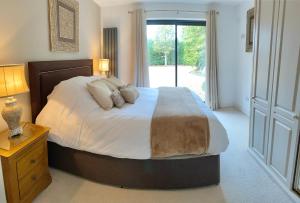 a bedroom with a large bed and a window at The Nook at Hillbrow in Romsey