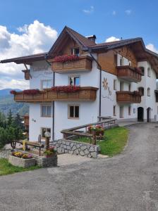 a large white building with balconies on a hill at Pension Lucknerhof in Maranza