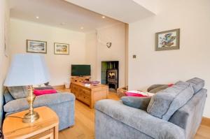 uma sala de estar com dois sofás e uma televisão em Kinnen Cottage em Creetown