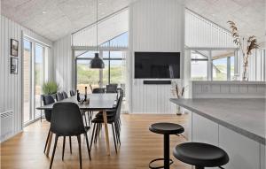 a kitchen and dining room with a table and chairs at Nice Home In Harbore With Sauna in Harboør