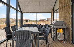 a patio with a table and chairs and a grill at Nice Home In Harbore With Sauna in Harboør