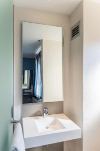 bagno con lavandino bianco e specchio di Road Lodge Isando a Germiston