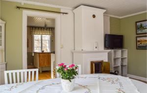 ein Esszimmer mit einem Tisch und einer Vase aus Blumen in der Unterkunft Nice Home In Bergshamra With Wifi in Bergshamra