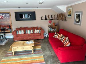 a living room with two red couches and a coffee table at The Wickerman Granary in Kirkcudbright