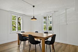 a dining room with a wooden table and chairs at Erlen Rooms in Lucerne