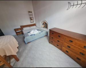 a bedroom with a bed and a wooden dresser at Paradise Studios in Myrtos