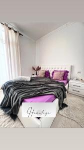 Un dormitorio blanco con una cama grande con almohadas moradas en Himalayas, en Gjirokastra