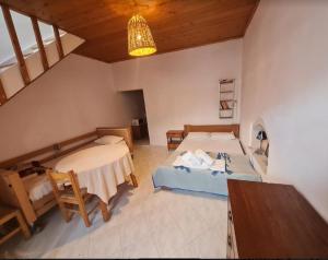 a bedroom with two beds and a table in a room at Paradise Studios in Myrtos