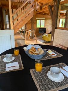 a table with a bowl of bread and a bowl of orange juice at Domaine Bourgade in Betbezer