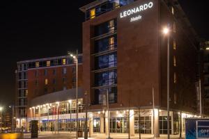 a building with a sign on the side of it at night at Leonardo Hotel Liverpool in Liverpool