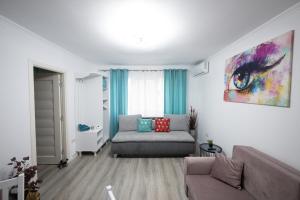a living room with a couch and a painting on the wall at L&R Boutique Apartment in Oţelu Roşu