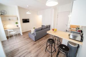 cocina y sala de estar con sofá y mesa en La Maison Gratte Ciel-Studio Villeurbanne-Jardin, en Villeurbanne