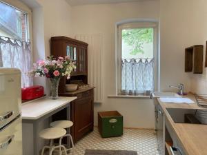 a kitchen with a vase of flowers on the counter at Ferienwohnung Luise in Münsingen