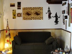 een woonkamer met een bank en wat foto's aan de muur bij Casa Claudia in Marsala