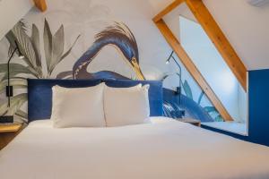 een slaapkamer met een kingsize bed met een vogel aan de muur bij Hotel St Joris I Kloeg Collection in Middelburg