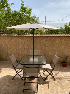 een tafel en stoelen met een parasol op een patio bij Vesuvio House in Boscoreale