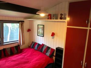 a small bedroom with a pink bed and a window at Lovely Holiday Home Close To The Beach And Nature in Rødby