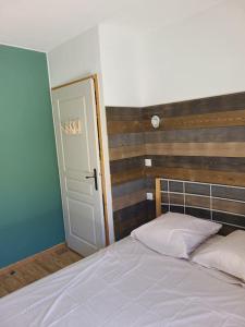 a bedroom with a white bed with a wooden headboard at Grand appartement au pied des pistes ! in Chamrousse