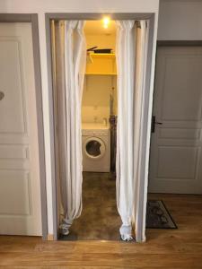 una puerta que conduce a una lavandería con lavadora en Grand appartement au pied des pistes !, en Chamrousse