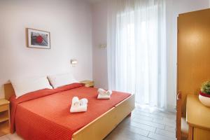 ein Schlafzimmer mit einem Bett mit weißen Schuhen darauf in der Unterkunft Hotel Raimondi in Bellaria-Igea Marina