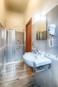 ein Badezimmer mit einem weißen Waschbecken und einer Dusche in der Unterkunft Hotel Raimondi in Bellaria-Igea Marina