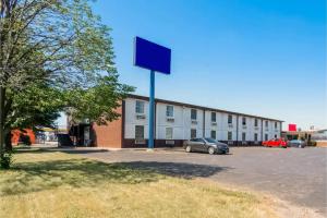 a large building with a car parked in a parking lot at OYO Hotel Morton East Peoria I-74 in Morton