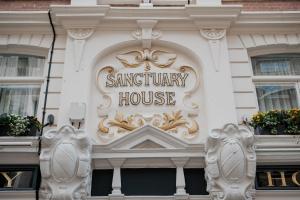 a santuary house sign on the side of a building at The Sanctuary House Hotel in London