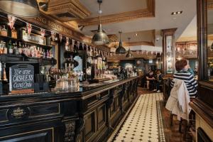 a man standing at a bar in a pub at The Sanctuary House Hotel in London