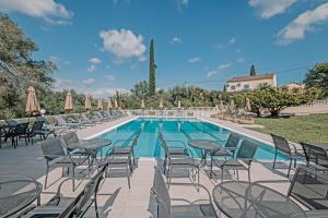 a swimming pool with chairs and a table and a pool at Pelithea Family Resort in Corfu