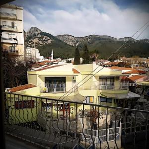 a yellow building with a balcony with mountains in the background at Centrally Apartments in Xanthi