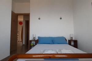 a bedroom with a large bed with blue pillows at Marirena in Kali Limenes