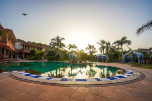 una piscina con palmeras en un complejo en Marugarh Resort and Spa, en Jodhpur