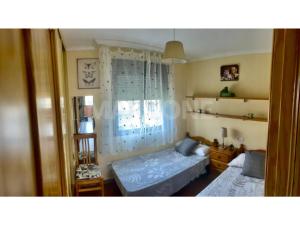 sypialnia z dwoma łóżkami i oknem w obiekcie Apartamento Vacacional A Lanzada w mieście Pontevedra