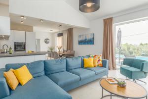 a living room with a blue couch and a kitchen at Villa Bella N in Višnjan