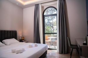 um quarto de hotel com uma cama e uma grande janela em All Seasons Boutique Hotel - Jerusalem em Jerusalém