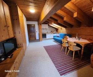 a kitchen and living room with a table and a tv at Gasthof Starzelhaus in Mittelberg