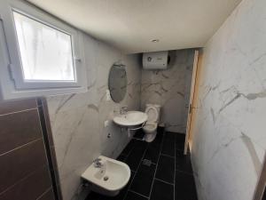 a small bathroom with a sink and a toilet at Sea & Relax Villa in Sarandë +22 photos