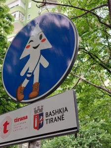 Una señal azul con un personaje de dibujos animados. en Tirana center en Tirana