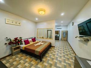 a bedroom with a bed and a television in a room at Trang Villa Hotel and Water Park in Trang