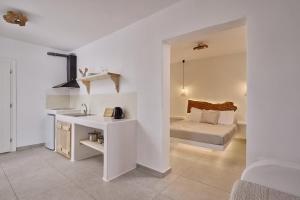 un bagno con lavandino e un letto in una camera di Casa Philippi Suites a Mykonos Città