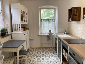 a kitchen with white cabinets and a sink and a window at Ferienwohnung Grete in Münsingen