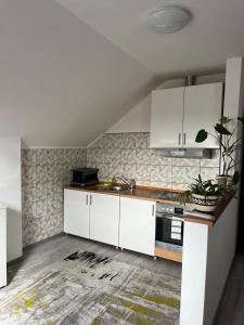 a kitchen with white cabinets and a sink at Apartman Salus in Tuzla