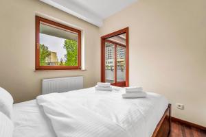 een slaapkamer met een wit bed en 2 ramen bij Malborska Metro Kondratowicza Apartment in Warschau