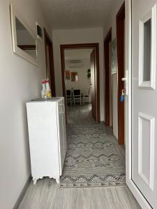 a hallway with a white refrigerator in a room at Apartman Salus in Tuzla