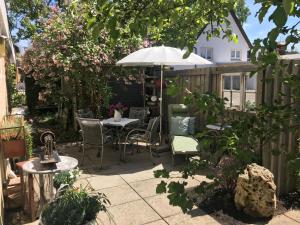 un patio con mesa, sillas y sombrilla en Ferienhaus Schillerstraße en Münsingen