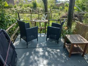 een patio met stoelen en een tafel en stoelen bij Tuinhuisje in het groen in Almere