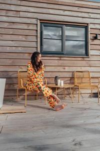 una mujer con un vestido sentada en una silla en Wonder Wagon at Trelan Farm, en Mold