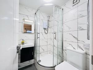 uma casa de banho com um chuveiro, um WC e um lavatório. em Battersea Studios by Sleepy em Londres