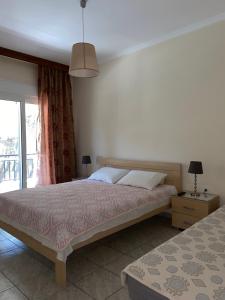 a bedroom with a bed and a window and a lamp at Villa Vasiliki in Metamorfosi